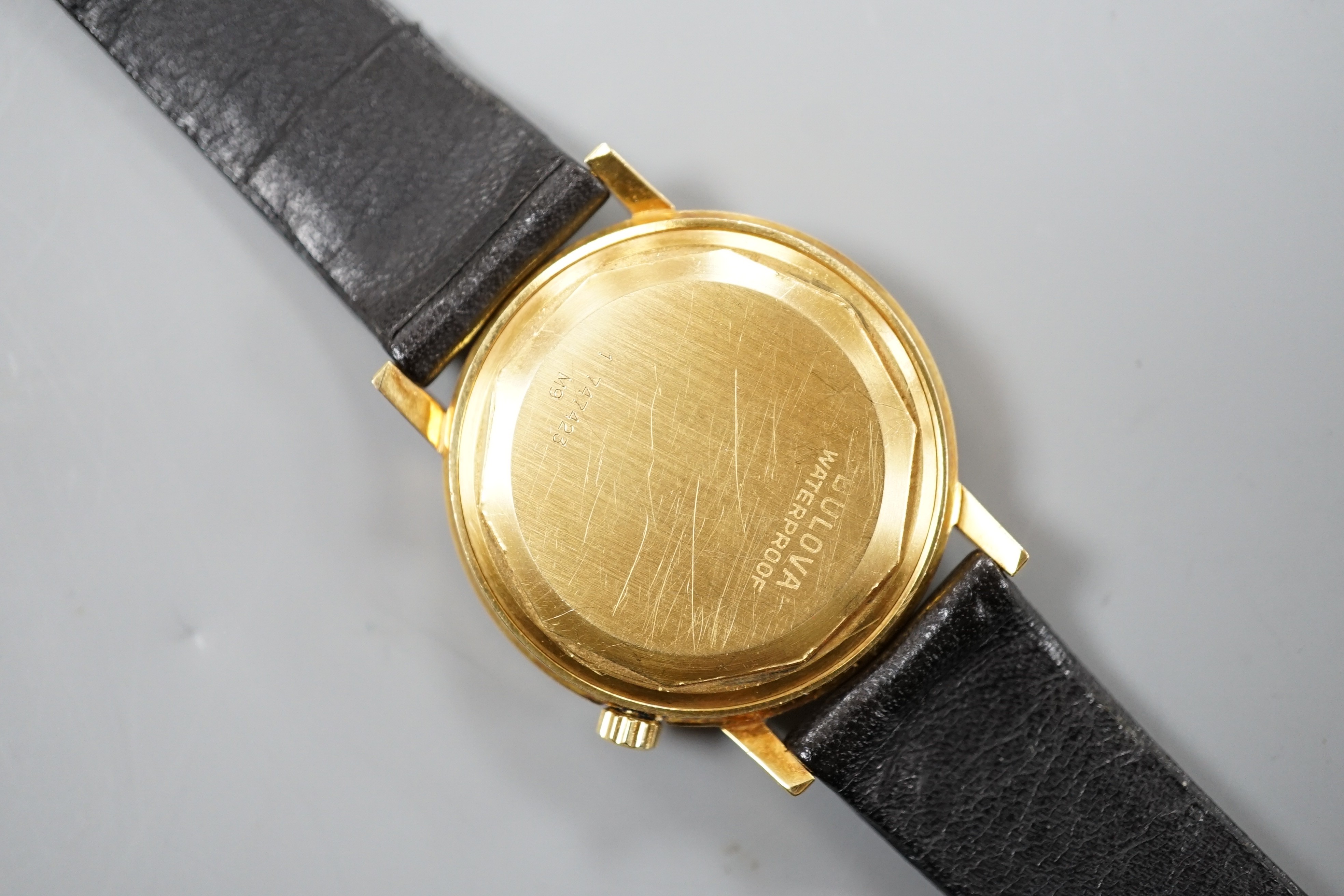 A gentleman's 750 yellow metal Bulova Accutron wrist watch, on a black leather strap, case diameter 34mm, gross weight 42.2 grams.